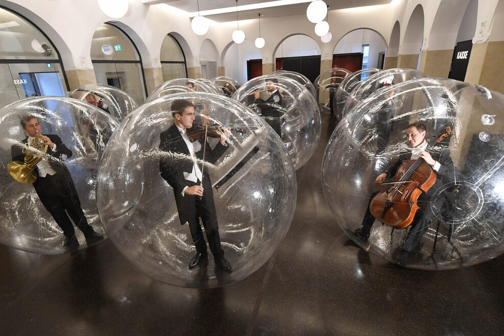 Musiker der Stuttgarter Philharmoniker spielen in großen durchsichtigen PVC-Luftblasen im Foyer des Gustav-Siegle-Hauses.