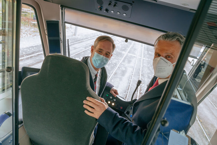 US-Generalkonsul Scharpf und Oberbürgermeister Nopper stehen im Führerhaus der Stadtbahn.