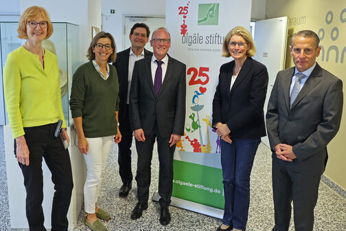 Bürgermeister Thomas Fuhrmann mit weiteren Personen vor einem Plakat der Olgäle Stiftung