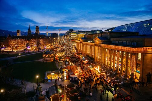 Aufnahme von oben bei Dunkelheit: der Weihnachtsmarkt am Schloßplatz mit weihnachtlicher Beleuchtung
