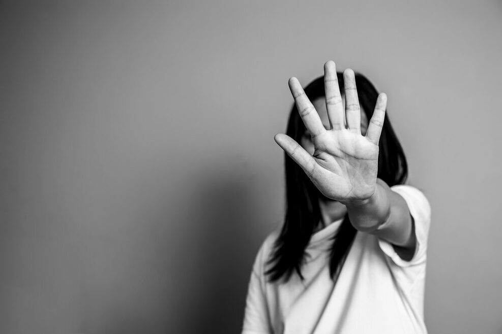 Eine Frau hält die ausgestreckte Hand vor sich und symbolisiert damit Stop.