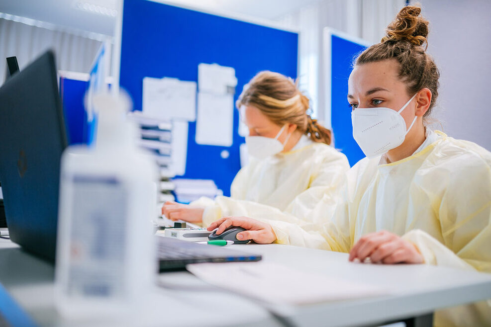 Zwei Studentinnen helfen im Corona-Testzentrum.