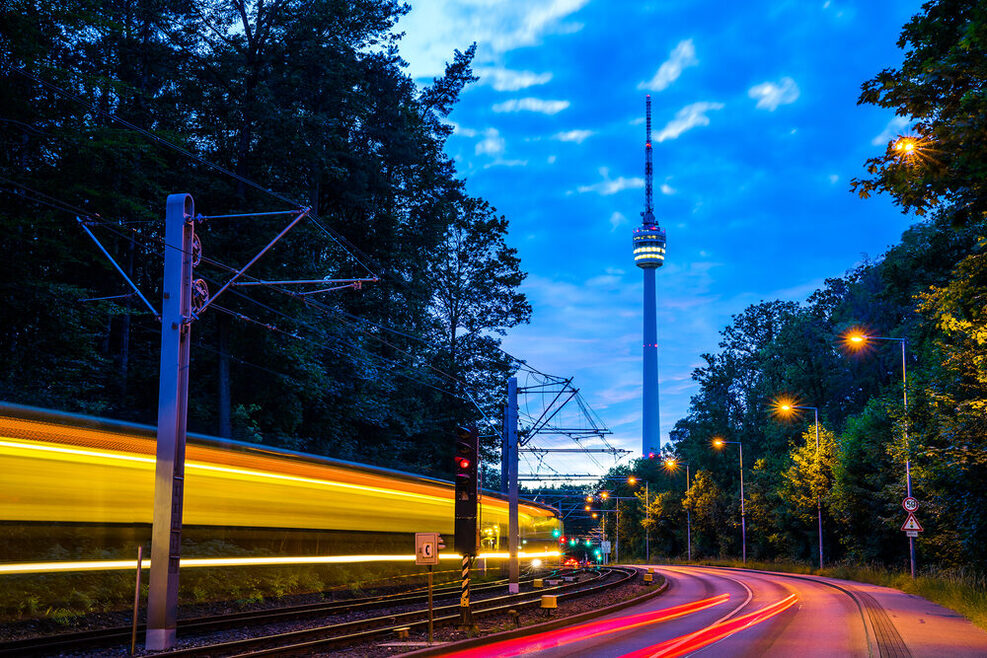 Stuttgart in der Abenddämmerung: Zu sehen ist in der Ferne der Fernsehturm und eine Stadtbahn.