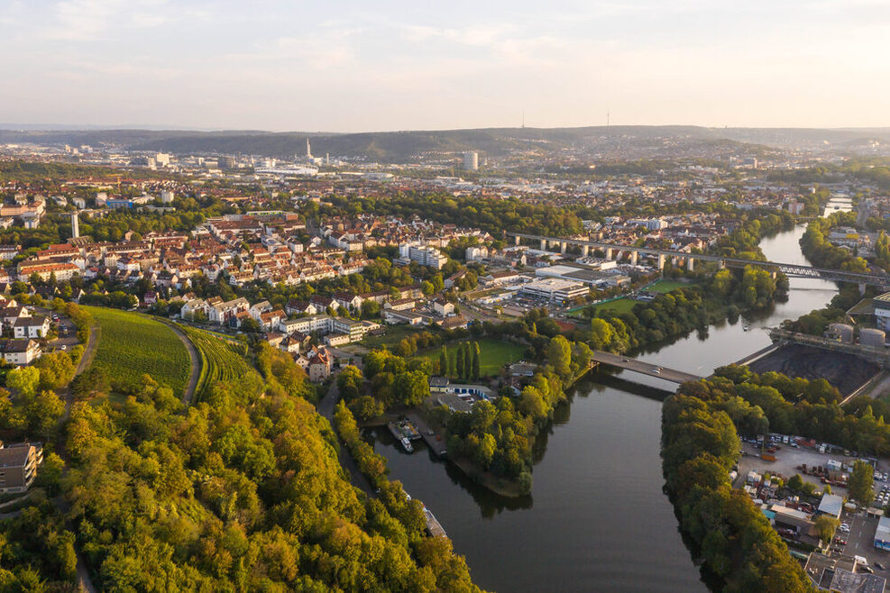 Das Drohnenfoto aus der Luft zeigt Münster mit Blickrichtung nach Bad Cannstatt. Die Hofenerstrasse verläuft entlang des Neckars mit dem Kohlelager auf dessen rechter Seite