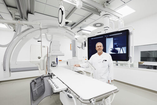 Ein Arzt zeigt eine Angiographie-Anlage