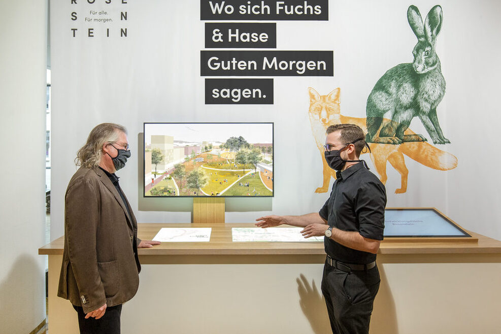 Fabian Schöttle (rechts), Leiter Kommunikation Rosenstein-Quartier, zeigt Bürgermeister Peter Pätzold (links) die Inhalte der neuen Ausstellung zum Rosenstein-Quartier.