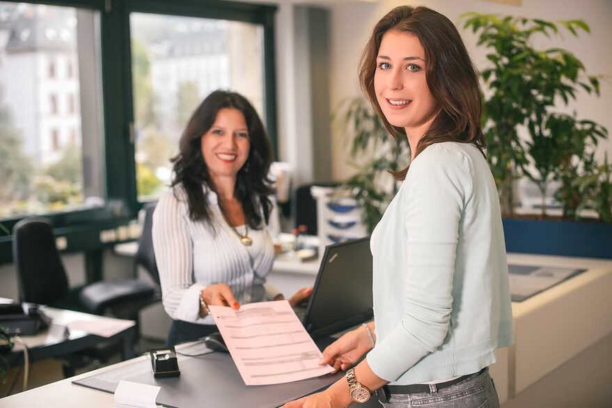 Junge Frau wird im Bürgerbüro von einer Mitarbeiterin der Stadt Stuttgart beraten.