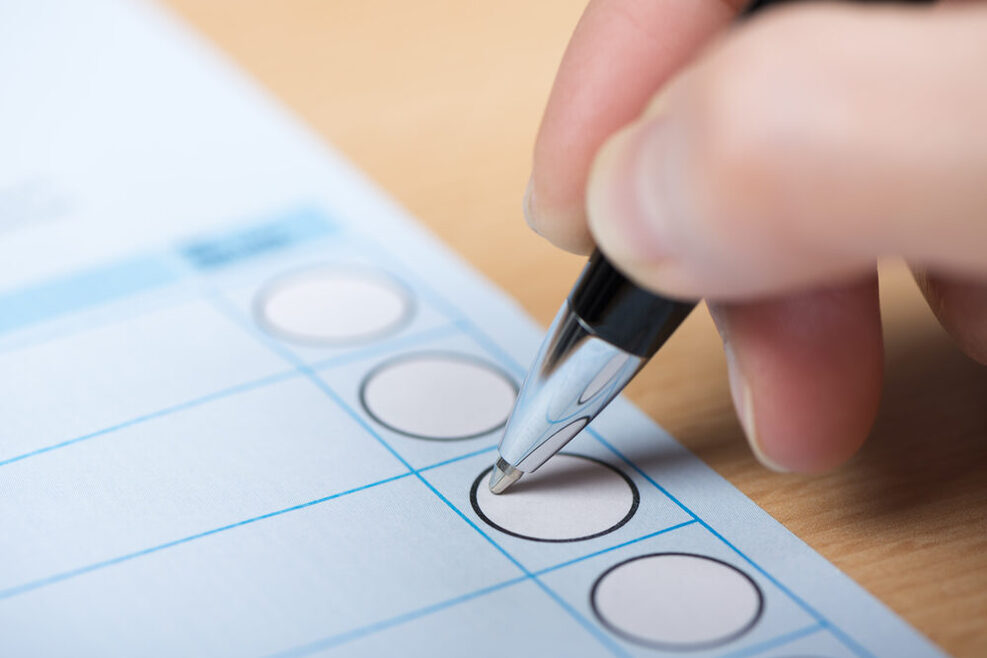 Stimmabgabe auf einem Stimmzettel mit Kugelschreiber.