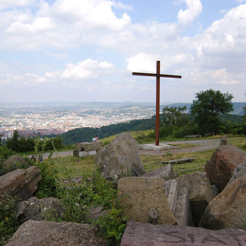 Birkenkopf mit Trümmerrreste des Zweiten Weltkrieges und Kreuz am Abhang.