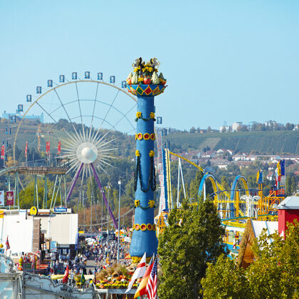 Luftaufnahme vom Cannstatter Volksfest: Zu sehen ist die Fruchtsäule, das Riesenrad und die Achterbahn.