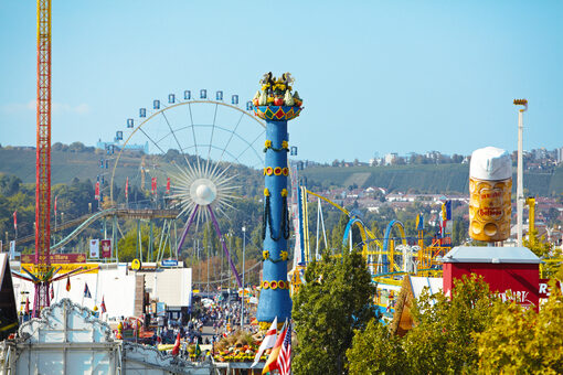 Luftaufnahme vom Cannstatter Volksfest: Zu sehen ist die Fruchtsäule, das Riesenrad und die Achterbahn.