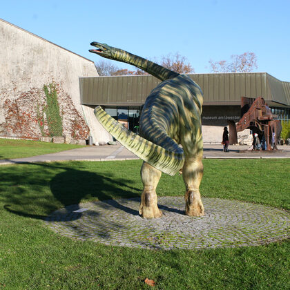 Museum am Löwentor im Rosensteinpark mit Dinsosaurier vor dem Eingang.