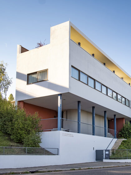 Außenansicht des Le Corbusier-Haus, mit weißer Fassade, langem Fensterband und klaren Linien.