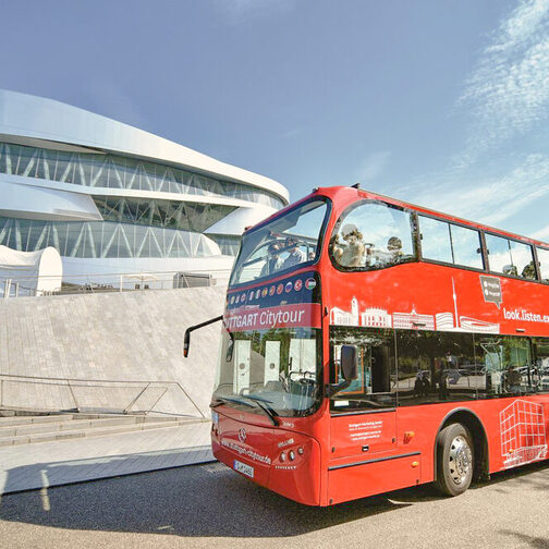 Ein roter Stuttgart Citytour-Bus steht vor dem Mercedes Benz-Museum.