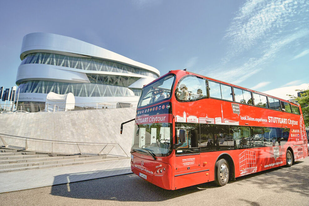 Ein roter Stuttgart Citytour-Bus steht vor dem Mercedes Benz-Museum.