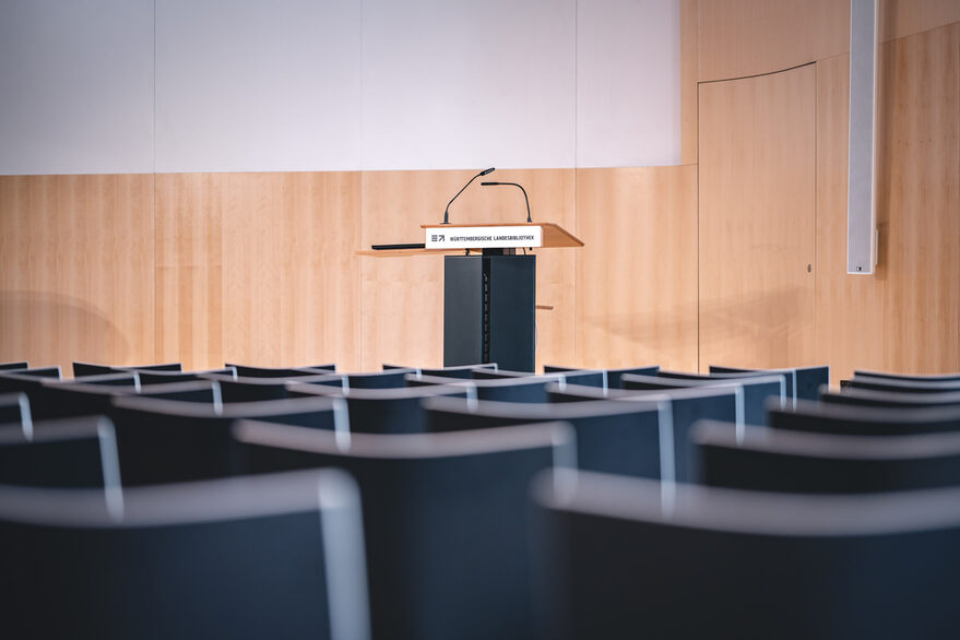 Stühle, ein Rednerpult auf der Bühne