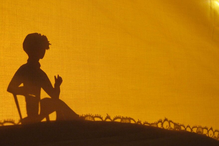 Oturan bir kişinin silueti.