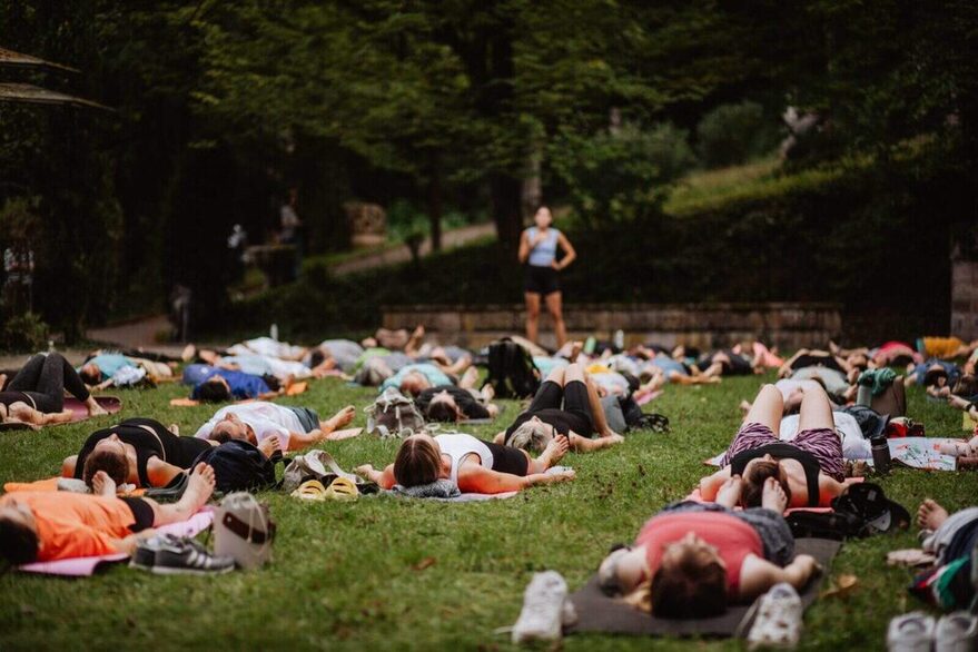 Menschen auf einer Wiese auf der Yogamatte