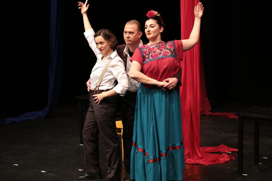 Zwei Schauspielerinnen und ein Schauspieler in tänzerischer Pose