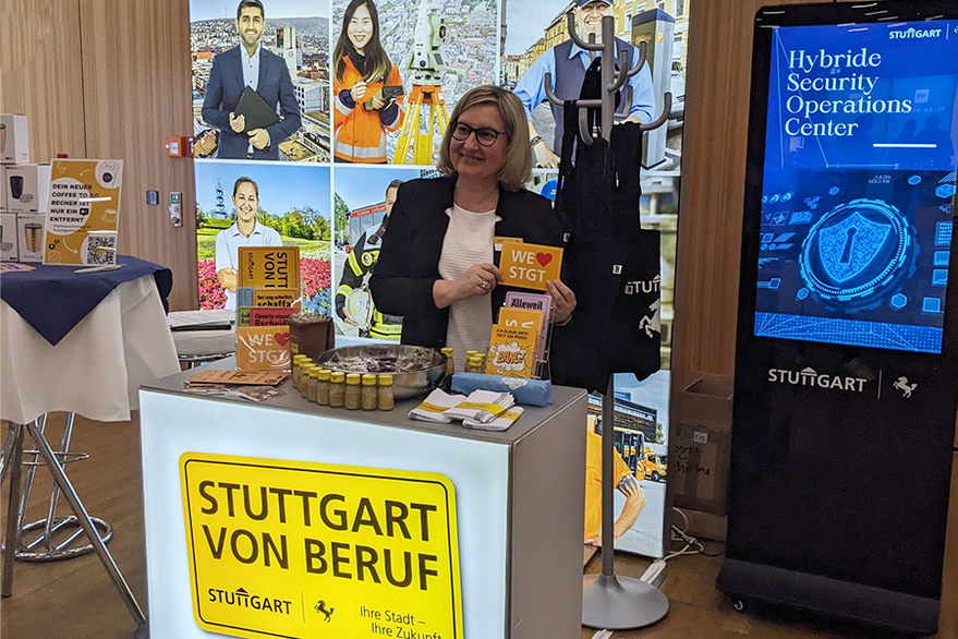 Mitarbeiterin der Stadt Stuttgart lächelt am Karrierestand in die Kamera