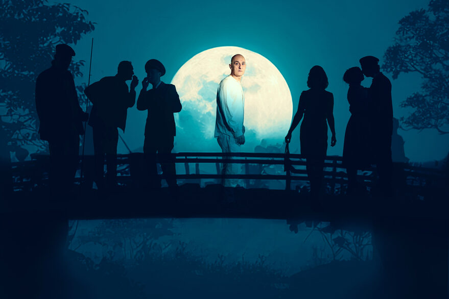 Ein Mann steht auf einer Brücke, vor dem hellen Vollmood