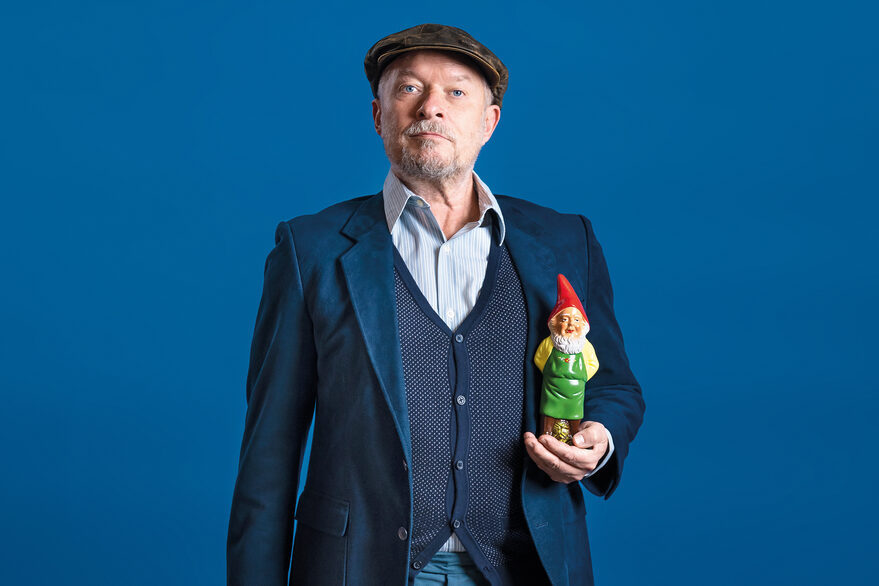 Mann, der einen Gartenzwerg in der Hand hält
