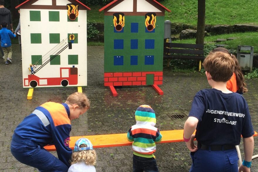 4 Kinder vor einer Spritzwand, Wasserspiele