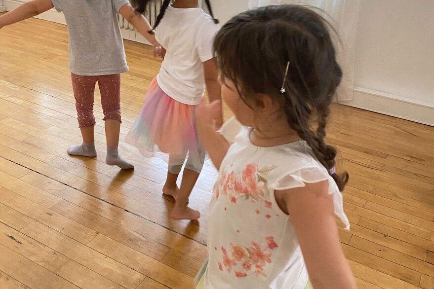 3 Kinder, die im Kreis tanzen