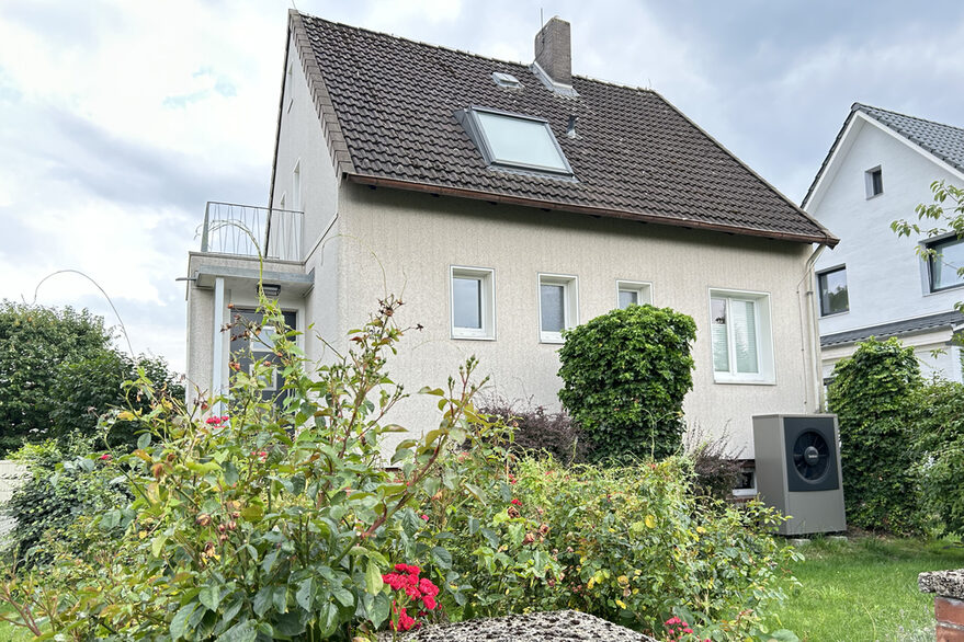 Ein älteres Einfamilienhaus mit einer Wärmepumpe