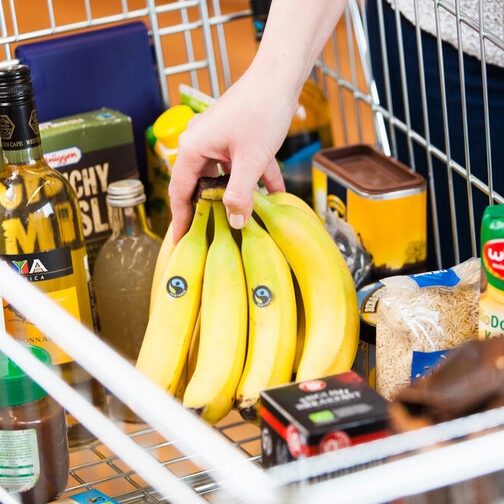 Mehrere Produkte mit Fairtrade-Siegel liegen in einem Einkaufswagen.