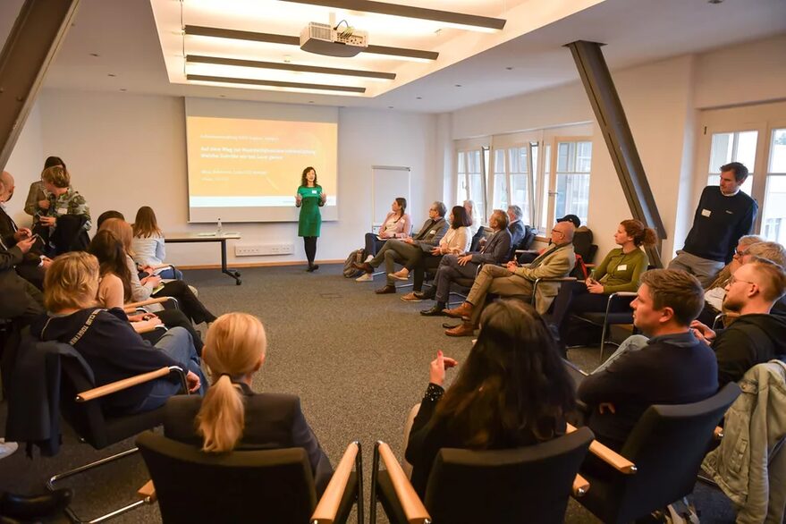 Menschen hören beim Workshop der Vortragenden zu.