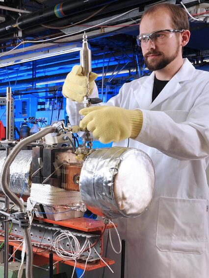 Ein Mann in einem weißen Laborkittel arbietet in einem Labor.